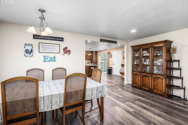 dining area with dark wood-style flooring, a chandelier, and recessed lighting