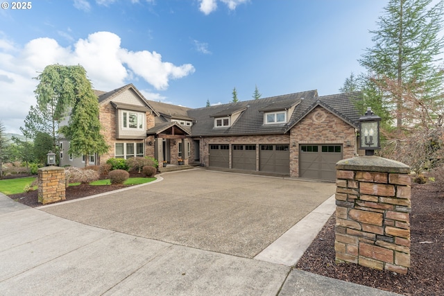 view of front of home featuring a garage, stone siding, concrete driveway, and brick siding