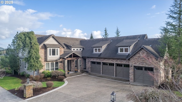 shingle-style home featuring a garage, concrete driveway, and stone siding