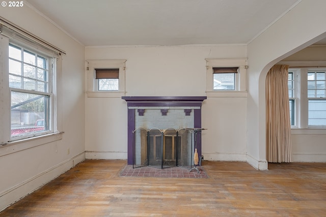 5417 NE 15th Ave, Portland, OR 97211 - unfurnished living room with plenty of natural light, arched walkways, wood finished floors, a brick fireplace, and crown molding