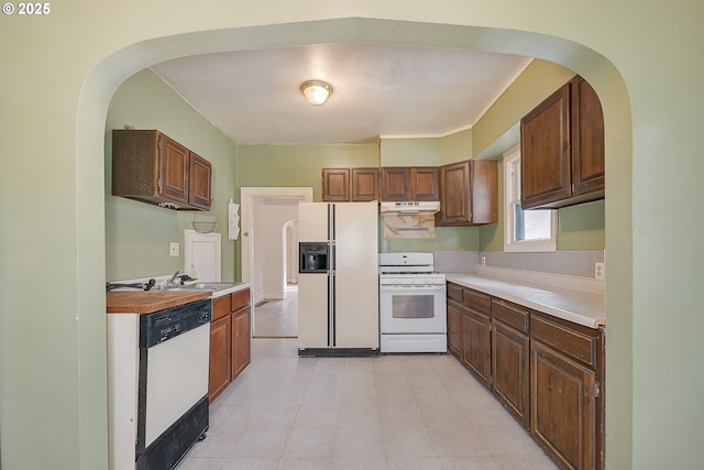 5417 NE 15th Ave, Portland, OR 97211 - kitchen with white appliances, under cabinet range hood, light countertops, and arched walkways
