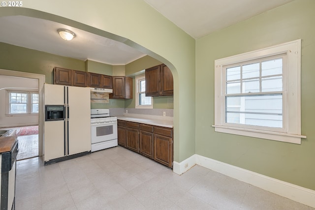 5417 NE 15th Ave, Portland, OR 97211 - kitchen featuring white appliances, under cabinet range hood, light countertops, and arched walkways