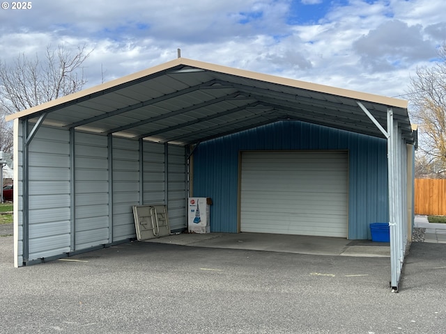 garage with a garage, fence, and driveway