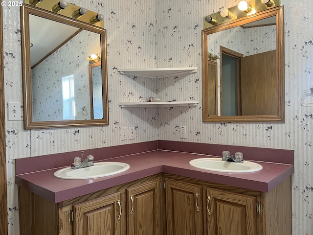 bathroom with vaulted ceiling, double vanity, a sink, and wallpapered walls