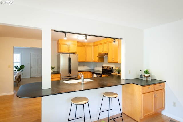 1379 Tucker Rd, Hood River, OR 97031 - kitchen featuring electric range oven, freestanding refrigerator, under cabinet range hood, dark countertops, and a sink