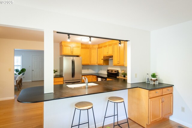 1379 Tucker Rd, Hood River, OR 97031 - kitchen featuring electric range oven, freestanding refrigerator, under cabinet range hood, dark countertops, and a sink