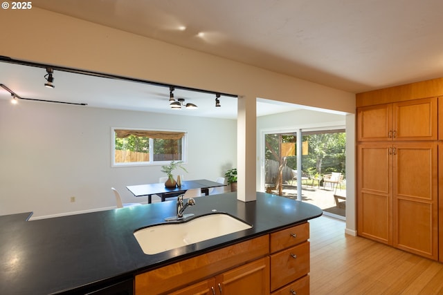 1379 Tucker Rd, Hood River, OR 97031 - kitchen with rail lighting, a sink, dark countertops, and brown cabinetry