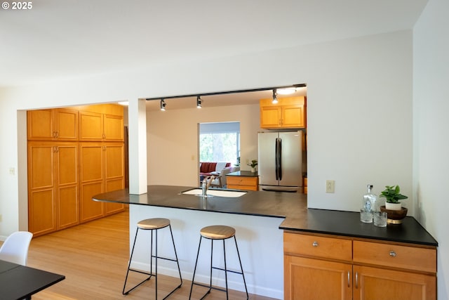 1379 Tucker Rd, Hood River, OR 97031 - kitchen with freestanding refrigerator, rail lighting, a sink, dark countertops, and a kitchen bar