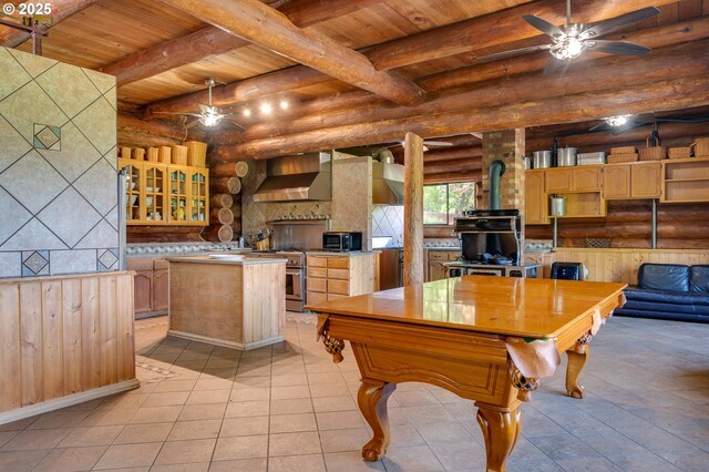 34643 Mountain View Pl NE, Albany, OR 97322 - recreation room featuring rustic walls, a ceiling fan, a wood stove, wooden ceiling with exposed beams, and light tile patterned floors