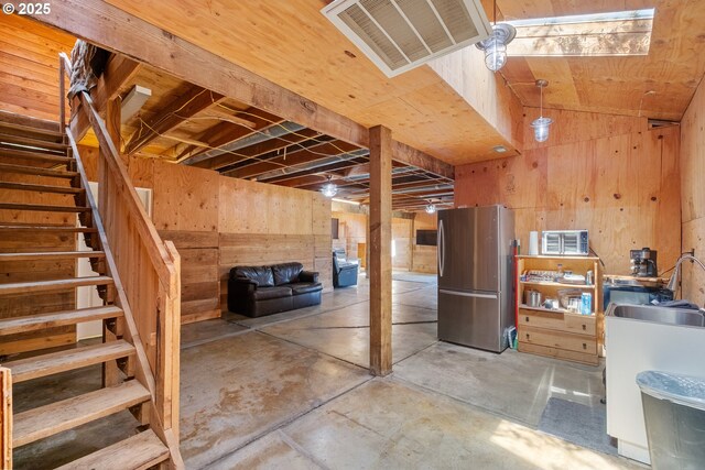 34643 Mountain View Pl NE, Albany, OR 97322 - unfinished below grade area featuring freestanding refrigerator, a sink, wooden walls, and stairway