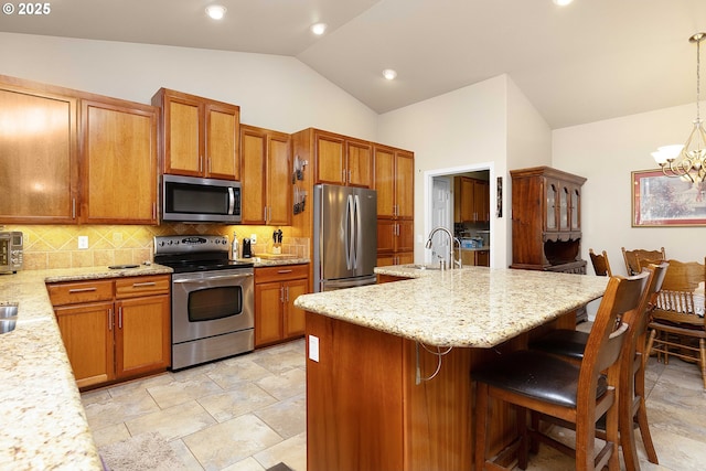 23164 N Umpqua Hwy, Idleyld Park, OR 97447 - kitchen featuring appliances with stainless steel finishes, lofted ceiling, backsplash, a kitchen bar, and brown cabinetry