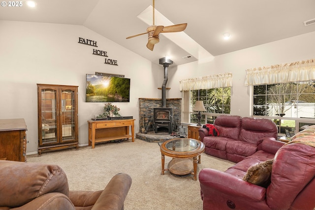 living room with a wood stove, visible vents, carpet floors, and ceiling fan