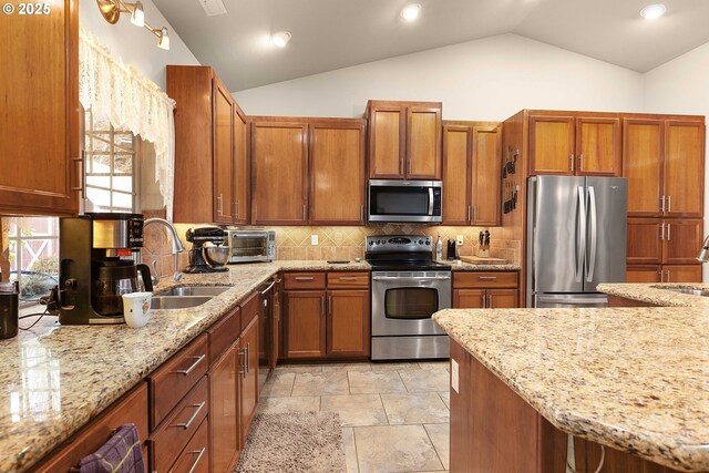 23164 N Umpqua Hwy, Idleyld Park, OR 97447 - kitchen with appliances with stainless steel finishes, lofted ceiling, brown cabinetry, light stone countertops, and recessed lighting