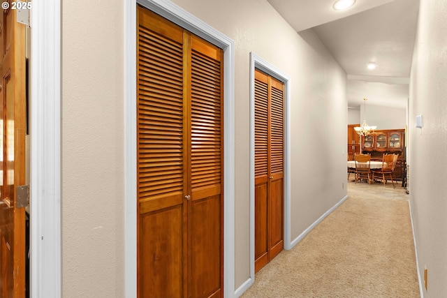 hallway with an inviting chandelier, carpet flooring, recessed lighting, and baseboards