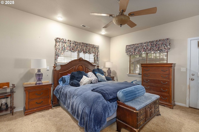 bedroom featuring visible vents, baseboards, light colored carpet, and ceiling fan