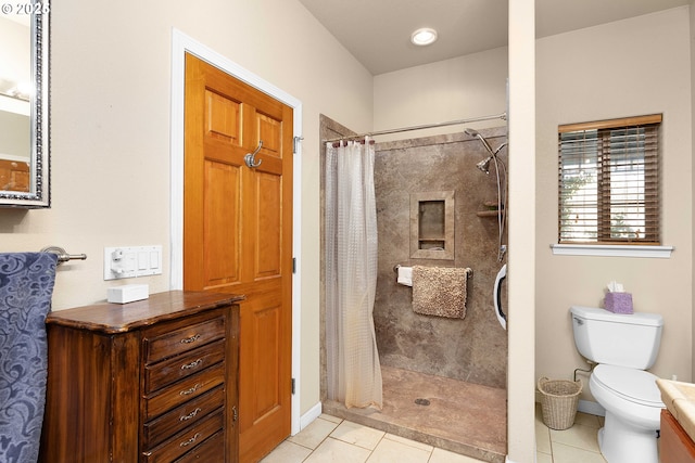 bathroom featuring toilet, tile patterned flooring, and a tile shower