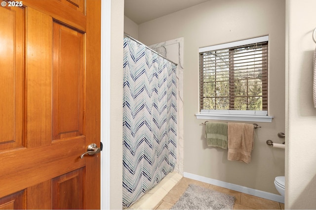 bathroom featuring curtained shower, tile patterned floors, toilet, and baseboards