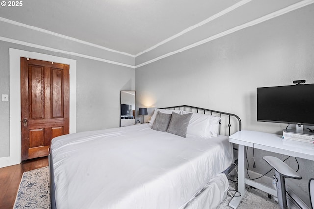 bedroom featuring ornamental molding, wood finished floors, and baseboards