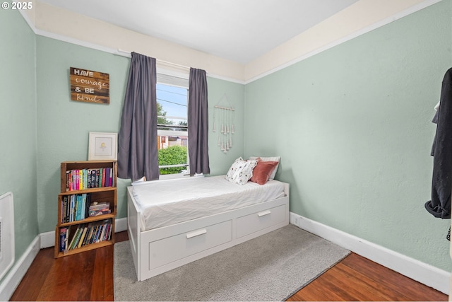 bedroom featuring wood finished floors and baseboards