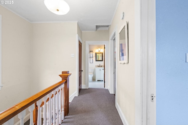 hallway with carpet floors, crown molding, baseboards, and an upstairs landing
