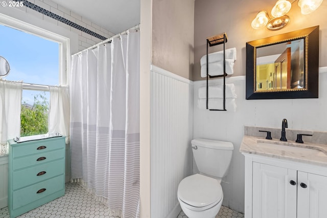 full bath featuring a wainscoted wall, toilet, vanity, and a shower with shower curtain