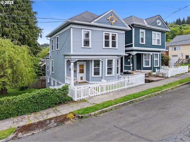 view of front of home with covered porch and a fenced front yard