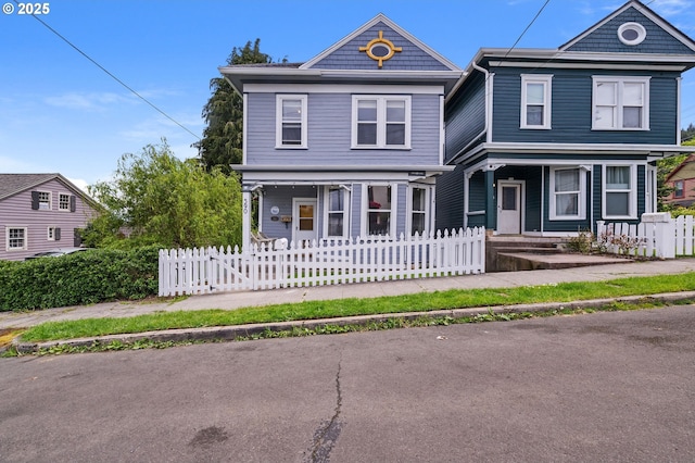 view of front facade with a porch and a fenced front yard