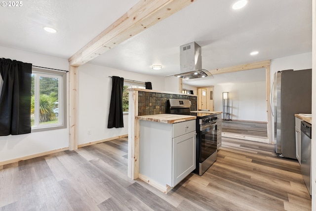 89311 Sutton Lake Dr, Florence, OR 97439 - kitchen with stainless steel appliances, island range hood, wood counters, light wood-type flooring, and recessed lighting
