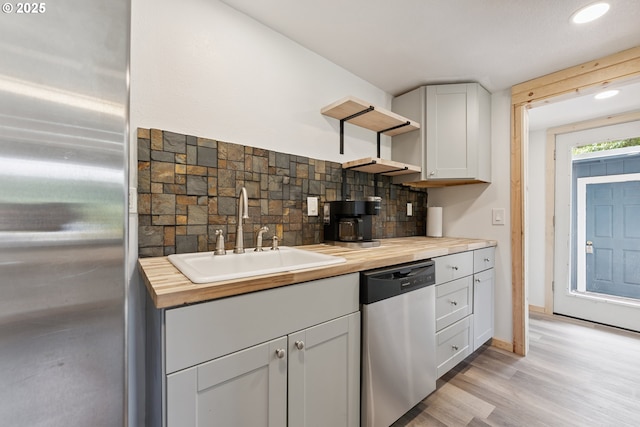 89311 Sutton Lake Dr, Florence, OR 97439 - kitchen with appliances with stainless steel finishes, butcher block countertops, open shelves, light wood-type flooring, and white cabinets