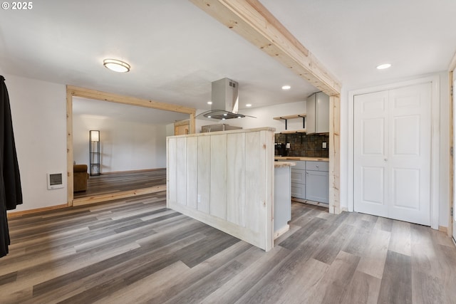 89311 Sutton Lake Dr, Florence, OR 97439 - kitchen with island range hood, light wood finished floors, backsplash, light countertops, and gray cabinetry