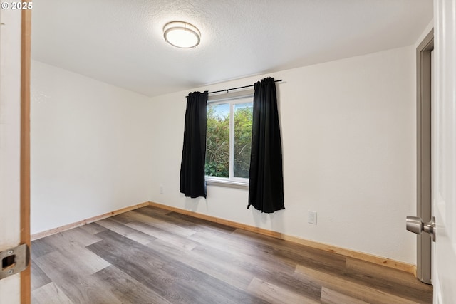 89311 Sutton Lake Dr, Florence, OR 97439 - unfurnished room with wood finished floors and a textured ceiling