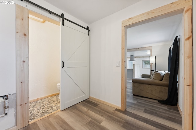89311 Sutton Lake Dr, Florence, OR 97439 - bedroom with a barn door and wood finished floors