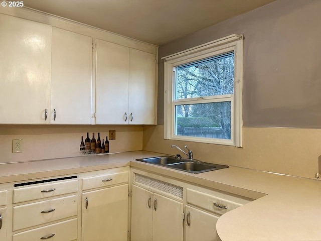 kitchen featuring sink and white cabinetry