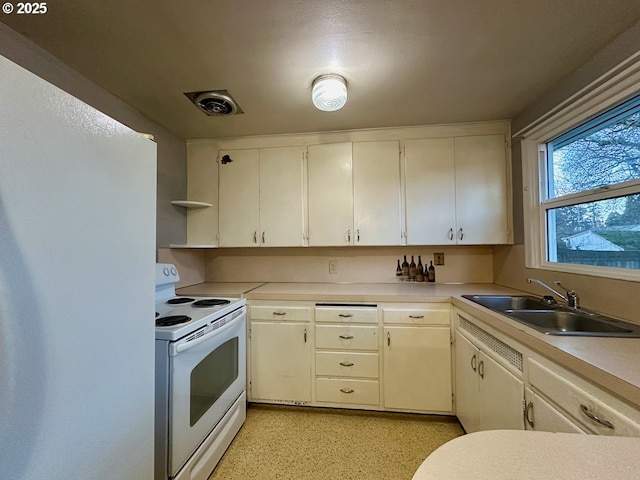 kitchen featuring sink, white appliances, and white cabinets