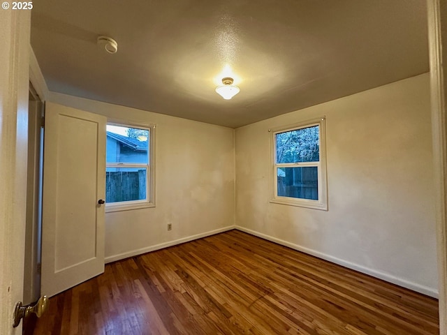 spare room with dark hardwood / wood-style floors