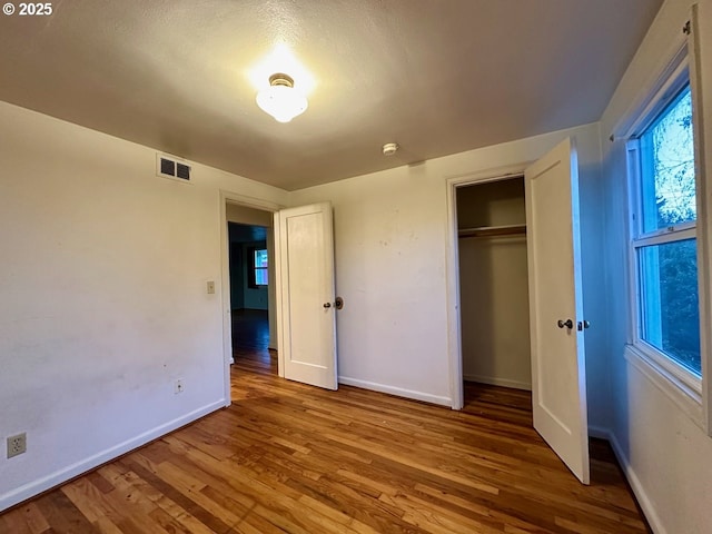 unfurnished bedroom featuring hardwood / wood-style flooring and a closet