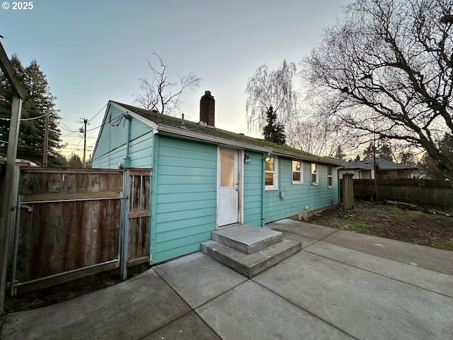 back house at dusk with a patio area