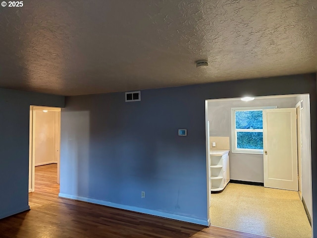 empty room featuring hardwood / wood-style floors and a textured ceiling