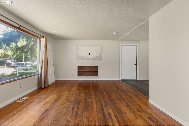 1203 NE 190th Pl, Portland, OR 97230 - unfurnished living room with a textured ceiling, wood finished floors, baseboards, and a fireplace
