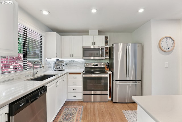 16905 Webster Rd, Gladstone, OR 97027 - kitchen featuring stainless steel appliances, a sink, decorative backsplash, white cabinets, and light countertops