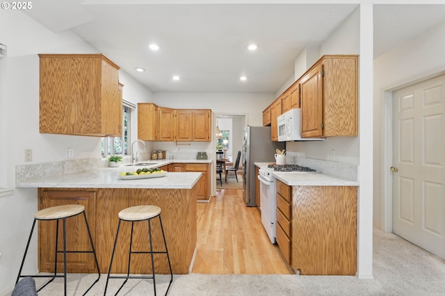 12028 SW Lesser Rd, Portland, OR 97219 - kitchen featuring white gas stove, a peninsula, healthy amount of natural light, light countertops, and recessed lighting