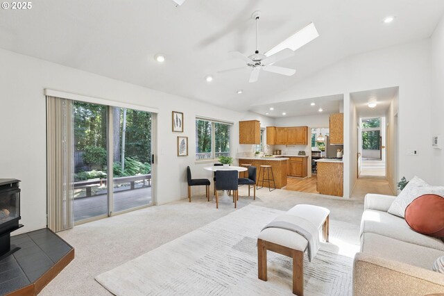 12028 SW Lesser Rd, Portland, OR 97219 - living room featuring a wood stove, lofted ceiling, recessed lighting, ceiling fan, and light colored carpet