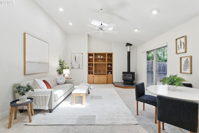 12028 SW Lesser Rd, Portland, OR 97219 - living area with a wood stove, vaulted ceiling, light carpet, a ceiling fan, and a skylight
