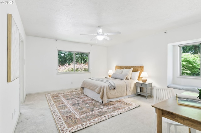 12028 SW Lesser Rd, Portland, OR 97219 - bedroom with light colored carpet, multiple windows, a textured ceiling, ceiling fan, and baseboards