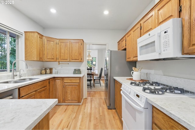12028 SW Lesser Rd, Portland, OR 97219 - kitchen featuring white appliances, a sink, light wood finished floors, recessed lighting, and brown cabinets