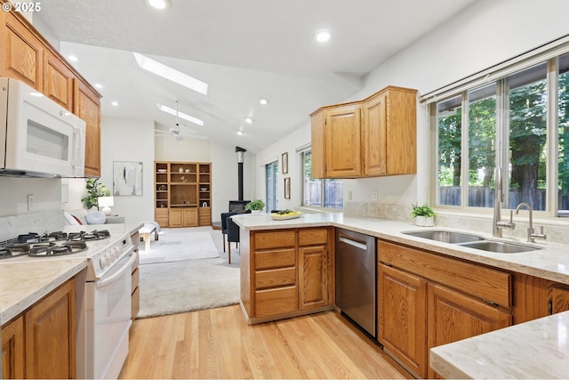 12028 SW Lesser Rd, Portland, OR 97219 - kitchen with white appliances, a skylight, a wood stove, healthy amount of natural light, and vaulted ceiling