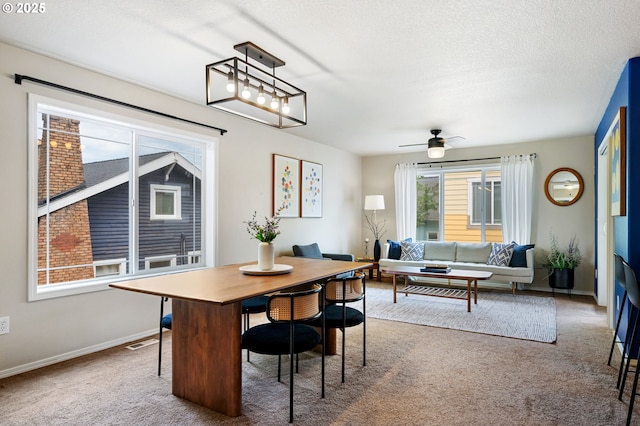 dining space featuring carpet, ceiling fan, baseboards, and a textured ceiling