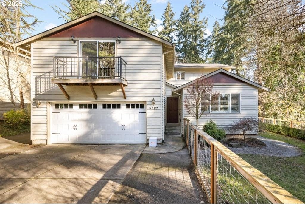 view of property with a balcony and a garage