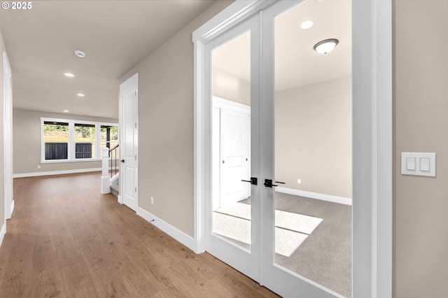 corridor featuring baseboards, light wood-style floors, and recessed lighting