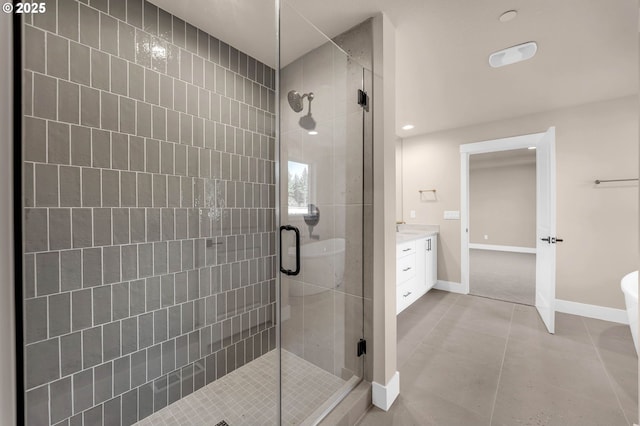 full bath with baseboards, vanity, tile patterned flooring, and a shower stall